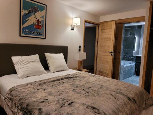 une chambre avec un grand lit dans une pièce dans l'établissement Appartement Spa Avec Terrasse, Billard, Babyfoot et Sauna à 500m des Pistes, Parking Inclus - FR-1-275-184, à La Rosière