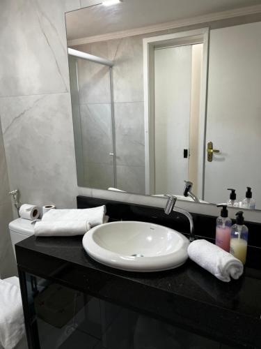 y baño con lavabo blanco y espejo. en Ap Aquaville resort -CE, en Aquiraz
