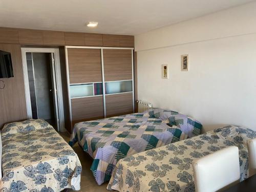 a bedroom with two beds and a window at Departamentos Eneas Frente al Mar in Mar del Plata