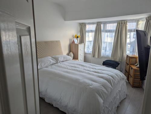 1 dormitorio con cama blanca y ventana en Spacious 2 bedroom house with garden, en Edmonton