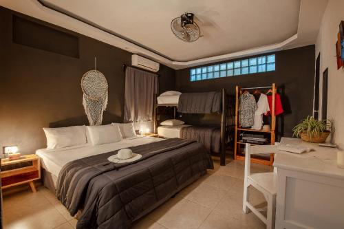 a bedroom with a bed with a hat on it at Che Playa Hostel & Bar Adults Only in Playa del Carmen