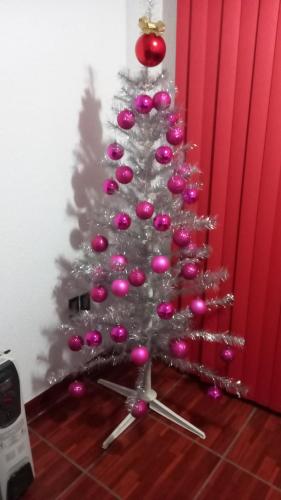 Uma árvore de Natal com ornamentos cor-de-rosa. em Boutique Hilda 