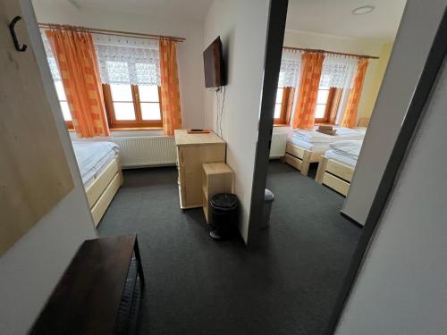 a view of a room with two beds and a television at Horský hotel Paprsek in Staré Město