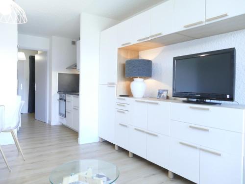 un salon blanc avec une télévision et une table dans l'établissement Studio rénové aux Deux Alpes - 4 pers, 29m² - FR-1-546-20, à Les Deux Alpes