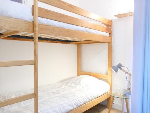- une chambre avec des lits superposés, un bureau et une lampe dans l'établissement Studio rénové aux Deux Alpes - 4 pers, 29m² - FR-1-546-20, à Les Deux Alpes