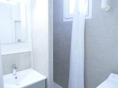 une salle de bain blanche avec un lavabo et une douche dans l'établissement Studio rénové aux Deux Alpes - 4 pers, 29m² - FR-1-546-20, à Les Deux Alpes