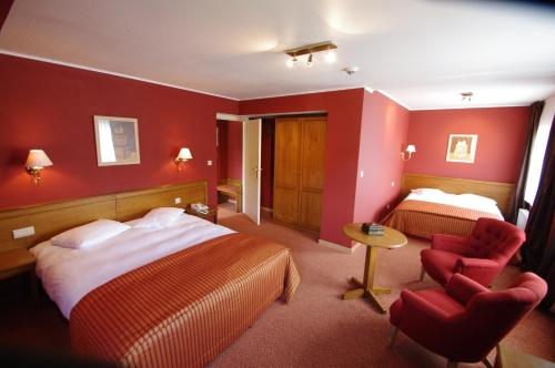 a hotel room with two beds and a red wall at Hôtel Panorama - Vue exceptionnelle sur la Semois in Bouillon