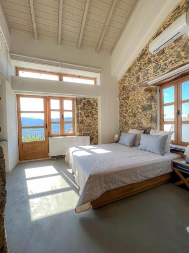 a bedroom with a large bed and a stone wall at The Stone House - Two Bedrooms Maisonette in Avdhoulianá
