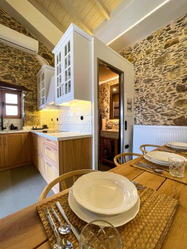 a kitchen with a wooden table with plates on it at The Stone House - Two Bedrooms Maisonette in Avdhoulianá
