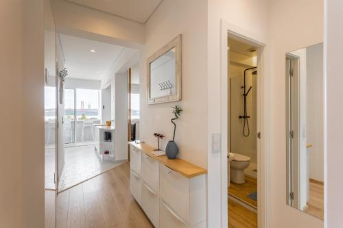 a white bathroom with a sink and a toilet at Tejo River View Apartment nearby Belém in Lisbon