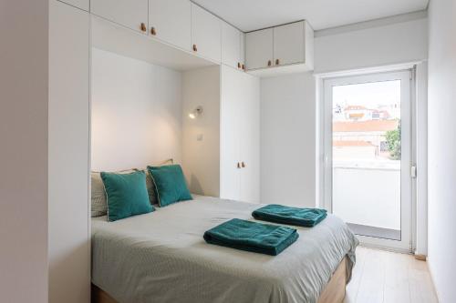 Un dormitorio con una cama con almohadas verdes. en Tejo River View Apartment nearby Belém en Lisboa