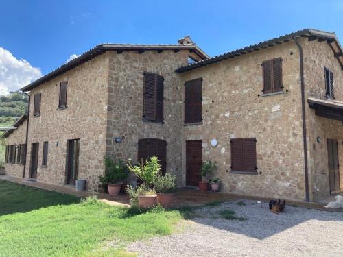 a large brick house with a cat sitting in front of it at Casale Riorso in Orvieto