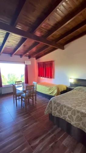 a bedroom with a bed and a table and chairs at Astrolabio Hostel in San Carlos de Bariloche