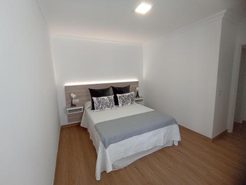 a white bedroom with a bed with two pillows at BL Holidays in Arrecife