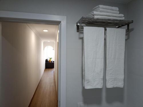 un corridoio con asciugamani bianchi su un appendiabiti in bagno di BL Holidays ad Arrecife