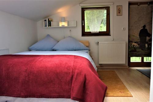 um quarto com uma cama com um cobertor vermelho em 5 Bergpanorama und herrliche alpinen Almlandschaft Nichtraucherdomizil em Schönau am Königssee