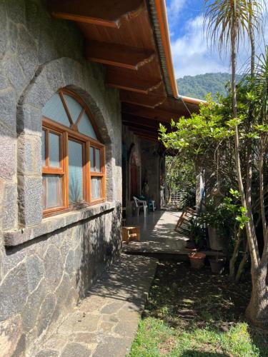 a stone house with a window and a patio at Casa Qatzij - Guest House, Lake Atitlan in San Lucas Tolimán