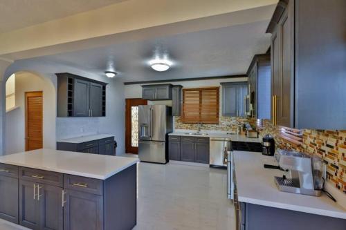 a large kitchen with blue cabinets and stainless steel appliances at Cheerful 3 -bedroom villa with Pool in Tortola Island
