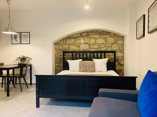 a bedroom with a bed with a stone wall at Cozy friendly place with free parking in Prague