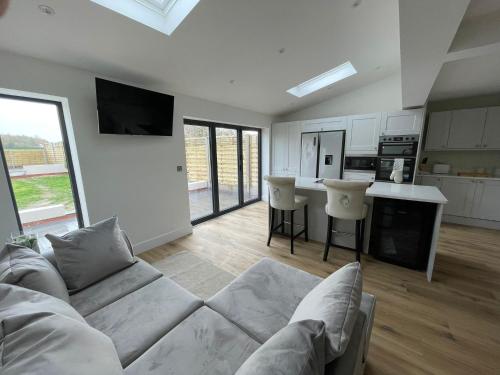 a living room with a couch and a kitchen at Newly renovated 3 Bed property - countryside views in Dunstall