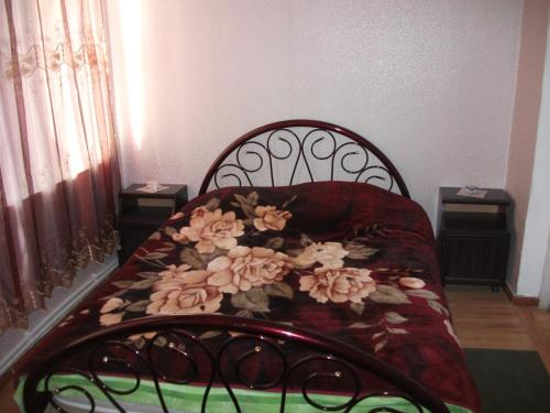 a bed with flowers on it in a room at Giorgi's Homestay in Kutaisi