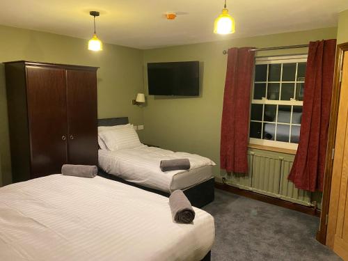 a hotel room with two beds and a flat screen tv at Unicorn in Selby