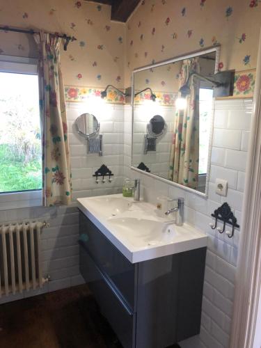 baño con lavabo, espejo y ventana en La Caleya de Abajo, en Cazanes