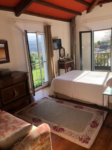 1 dormitorio con 1 cama grande y balcón en La Caleya de Abajo, en Cazanes