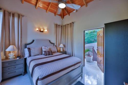 a bedroom with a large bed and a balcony at Modern 3-bedroom villa with pool in Tortola Island