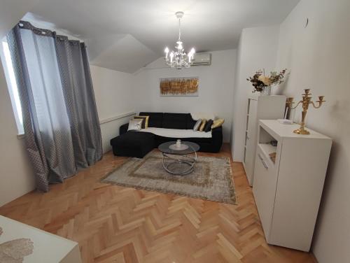 ein Wohnzimmer mit einem Sofa und einem Tisch in der Unterkunft Apartman Oaza - Ploče, Croatia in Ploče