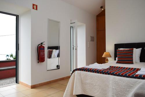 - une chambre avec un lit et un extincteur dans l'établissement Cicas Studio, a Home in Madeira, à Arco da Calheta