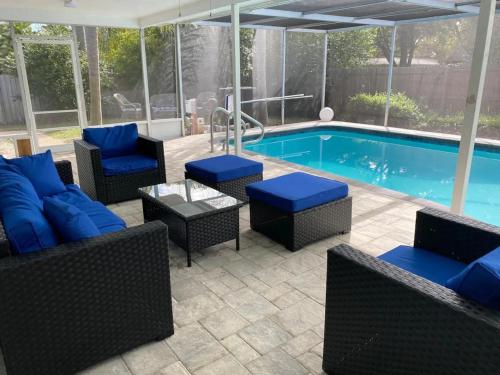 a patio with blue furniture and a swimming pool at Spacious 5 bedrooms 3 bathrooms Family-Friendly Home With Heated salt Pool in Clearwater