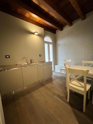 una cucina con lavandino e tavolo con sedie di V&B Suites and Apartments a Pavia