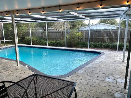 a swimming pool under a pergola with a swimming poolvisor at Spacious 5 bedrooms 3 bathrooms Family-Friendly Home With Heated salt Pool in Clearwater