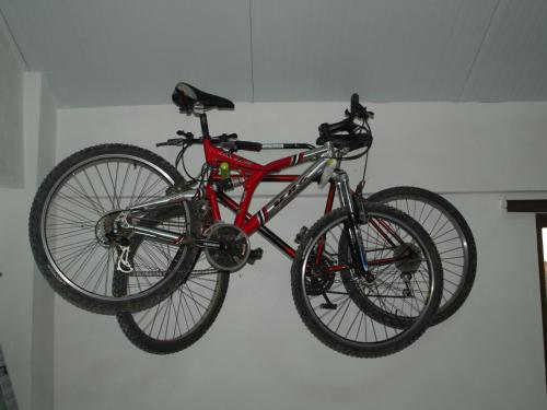 una bicicletta rossa appesa a un muro di The Windhouse a São Bartolomeu