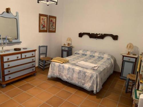 1 dormitorio con cama, tocador y espejo en EL CONVENTO Vivienda Rural Jaén Andalucía España en Carchelejo