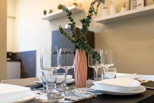 una mesa con gafas y un jarrón con una planta en Vista Mole, Centro a 15 min - Luxury Suites & fast WiFi, en Turín