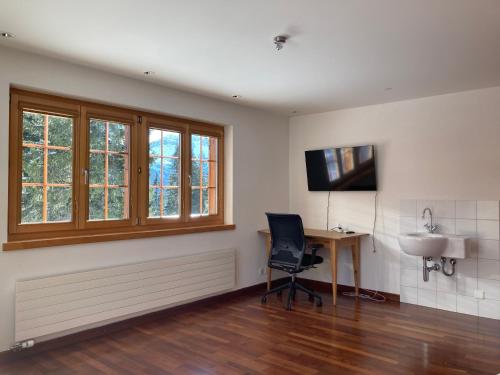 a room with a desk and a chair and a television at Guardaval in Arosa