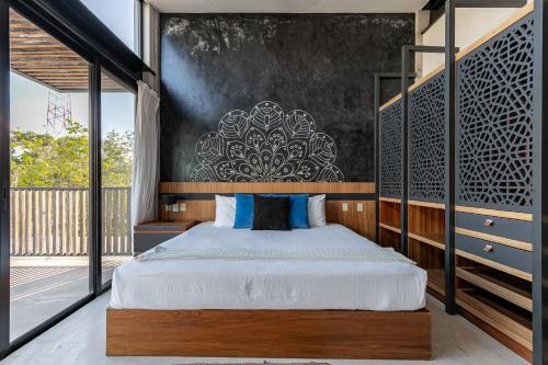 a bedroom with a bed and a large window at Lumina at Mudra Tulum in Tulum