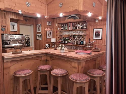 - une cuisine avec un bar avec des tabourets dans l'établissement Hôtel Les Triolets, à Châtel