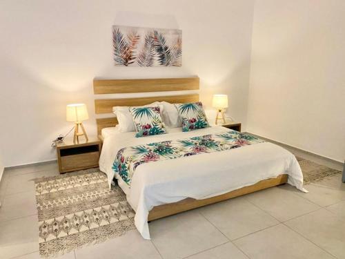 een slaapkamer met een groot bed en 2 lampen bij Luxury beach house with spectacular sea view and pool in Trou aux Biches