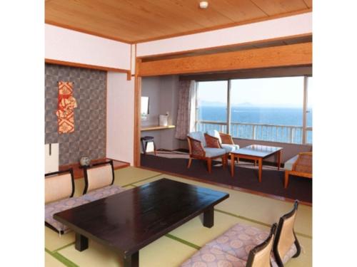 a living room with a table and chairs at Hotel Mikawa Kaiyoukaku - Vacation STAY 90625v in Gamagōri