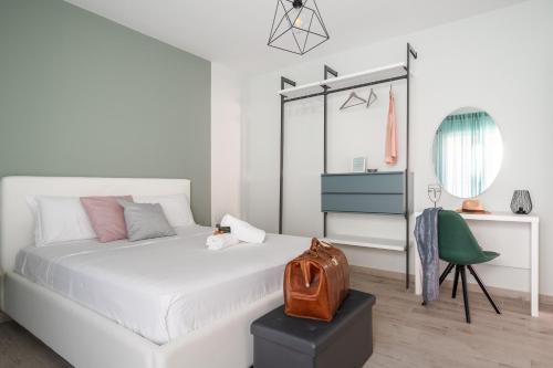 um quarto branco com uma cama branca e uma cadeira verde em Family Terrace Suite - Volturno3 Suites & more em Mazara del Vallo