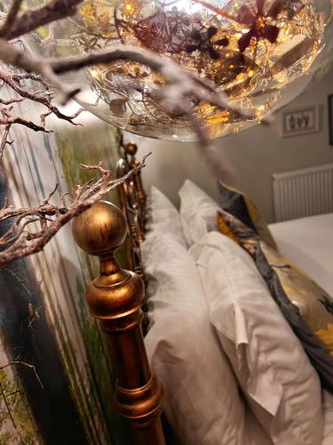 a bedroom with a bed with a chandelier above it at Luxury tree-house with optional ESPA Spa in Canterbury