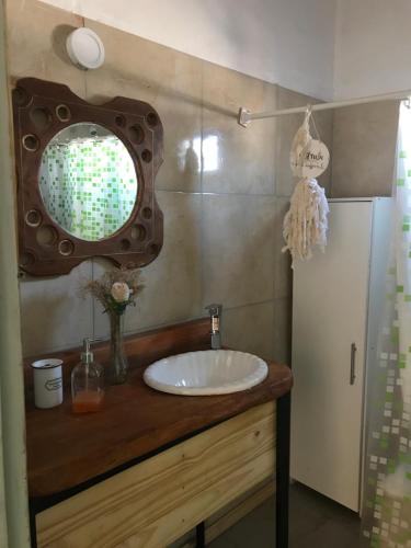 La salle de bains est pourvue d'un lavabo et d'un miroir sur un comptoir. dans l'établissement Los Chañares, à San Carlos