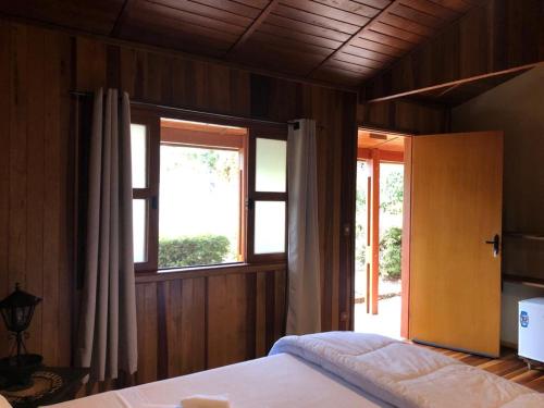 um quarto com uma cama e uma janela em Estância Travessia em São Pedro