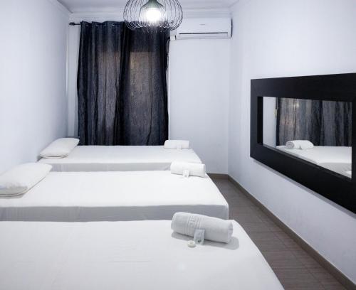 Habitación con 2 camas y espejo. en Hostal Andrea, en Madrid