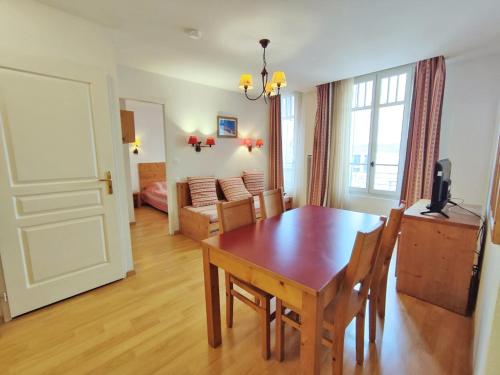 une salle à manger avec une table et un salon dans l'établissement Evasion, T3, centre Luchon, wifi, casier à skis, ascenseur, 6 personnes, à Luchon