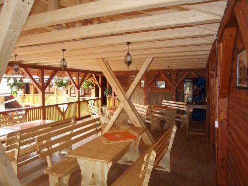 a wooden pavilion with benches and tables in it at Pensiunea Elisabeta in Sovata