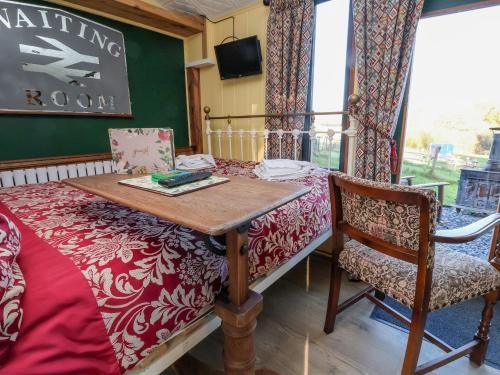 a room with a table and a bed and a chair at The Suffolk in St Asaph
